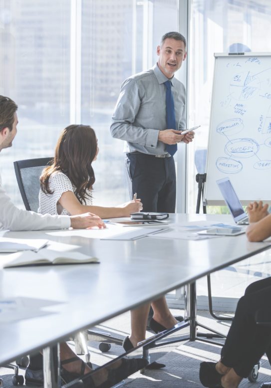 mature-businessman-giving-a-presentation-to-his-team--838989702-5b61c988c9e77c0050197eec